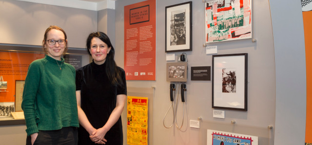 Two academic women standing in front of a display