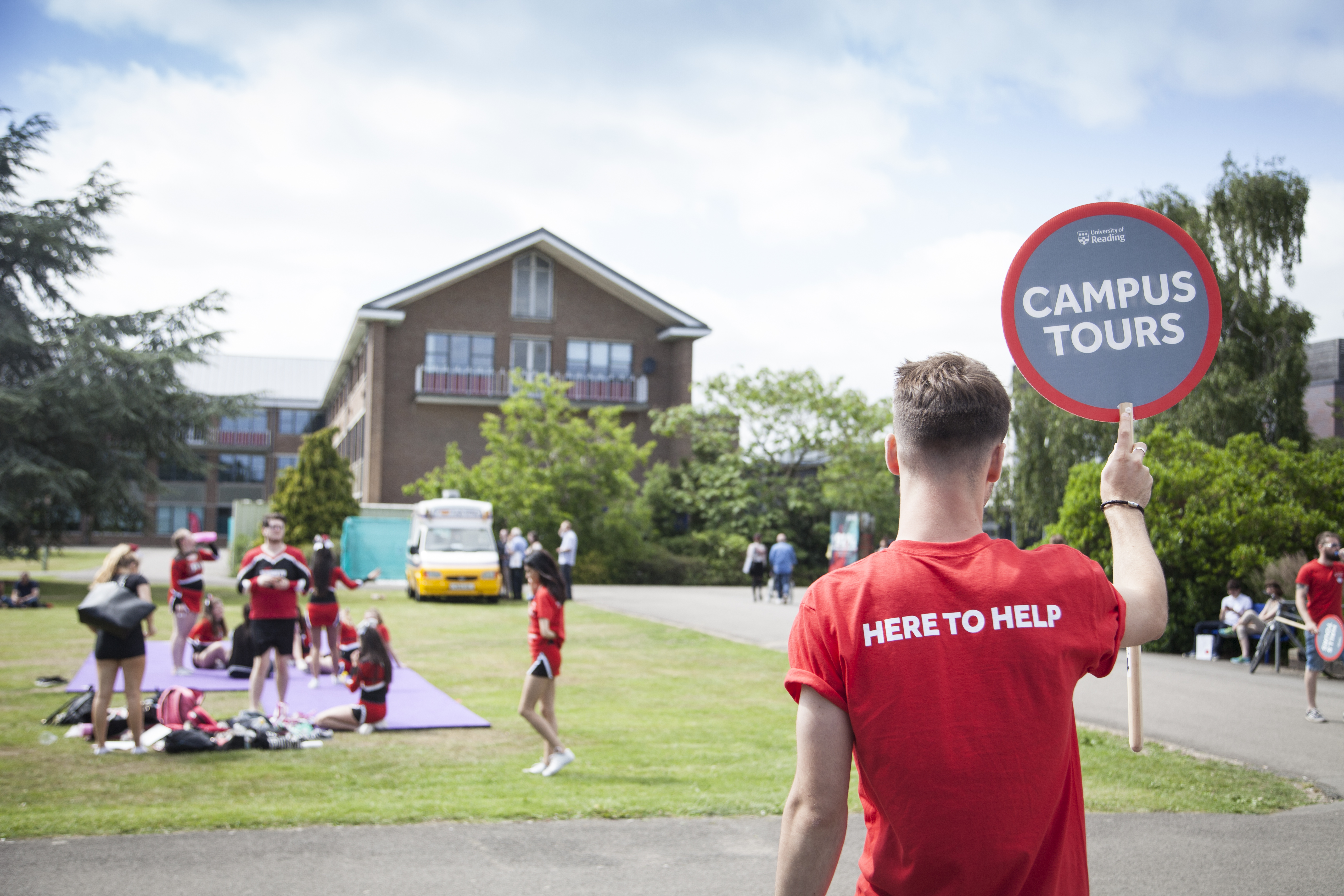 Student ambassador with campus tour banner on Whiteknights Campus